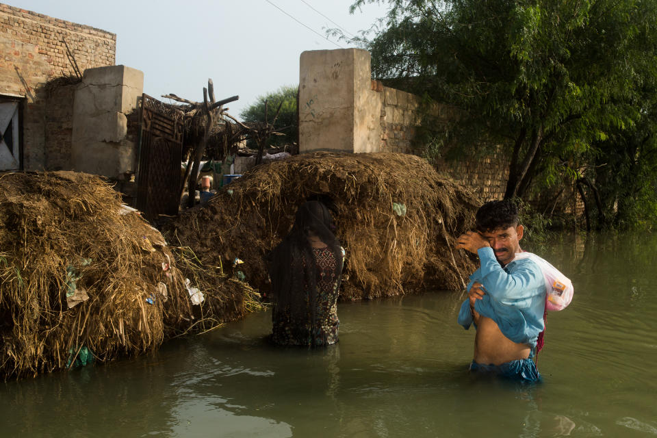 Residents of Rajo Nizamani in Sindh province wading through flood water to get to their home, Sept. 10.<span class="copyright">Hassaan Gondal for TIME</span>