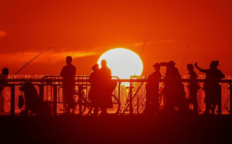 FILE PHOTO: People stand on a pier in the Baltic Sea resort of Zelenogradsk