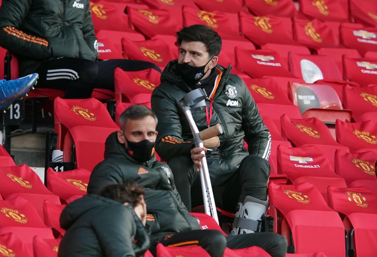 Harry Maguire watches on from the stands at Old Trafford (Reuters)