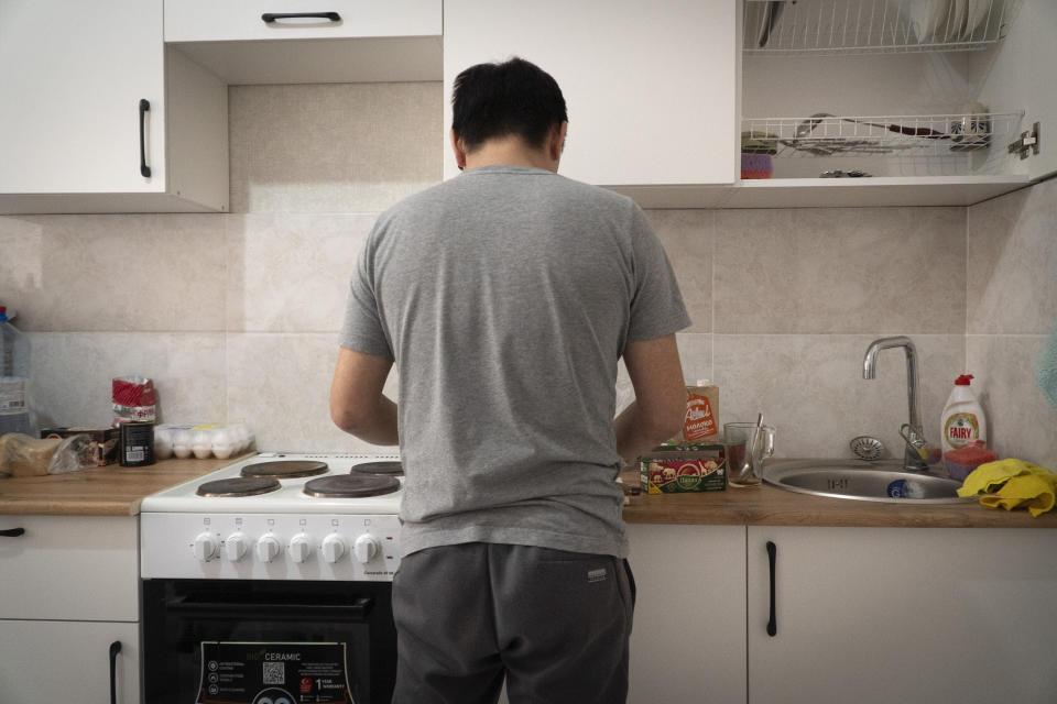 A Russian soldier who goes by the nickname Sparrow prepares tea at his apartment in Astana, Kazakhstan, in late 2023. After being forcibly conscripted, he ran away from his barracks because he didn't want to kill anyone. Now he faces criminal charges in Russia. "I don't want anything in life. I have no interest in my own affairs," he said. "I just sit all day on the Internet, on YouTube, and read news, news, news of what's going on in Ukraine, and that's it." (AP Photo)