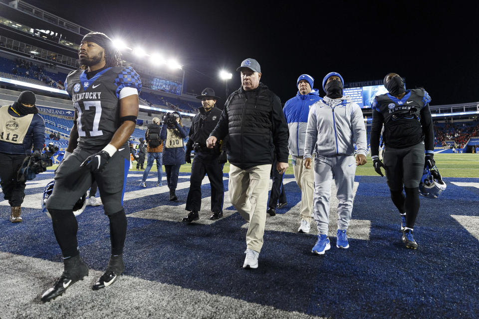 Kentucky head coach Mark Stoops, middle, walks off the field after losing to Georgia in an NCAA college football game in Lexington, Ky., Saturday, Nov. 19, 2022. (AP Photo/Michael Clubb)