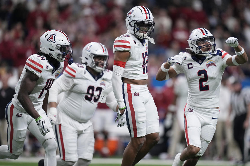 Arizona safety Genesis Smith (12) celebrates with teammates after an interception against Oklahoma during the first half of the Alamo Bowl NCAA college football game in San Antonio, Thursday, Dec. 28, 2023. (AP Photo/Eric Gay)