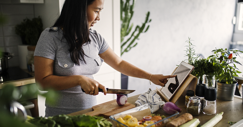 woman cooking in the kitchen using her tablet