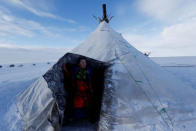 A woman from the indigenous community "Yamb To" (Long Lake) looks out a tent at a reindeer camping ground, about 450 km northeast of Naryan-Mar, in Nenets Autonomous District, Russia, March 1, 2018. REUTERS/Sergei Karpukhin