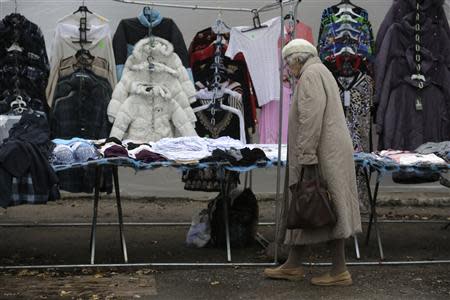 A woman looks at clothes displayed for sale at a street market in Valka October 26, 2013. REUTERS/Ints Kalnins