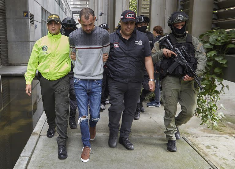 En esta foto distribuida por la Oficina de Prensa de la Fiscalía General de Colombia, la policía escolta a Wendre Still Scott Carrillo luego de ser capturado en Medellín, Colombia, el viernes 3 de junio de 2022. Las autoridades colombianas acusan a Wendre Still Scott Carrillo de participar en el asesinato del fiscal paraguayo Marcelo Pecci en Cartagena. (Colombia's Attorney General Press Office via AP)