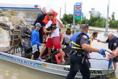 Harris County Sheriff deputies help residents evacuate from high water in the Wimbledon Champions subdivision of Houston, Texas April 20, 2016. REUTERS/Harris County Sheriff's Office/Handout via Reuters