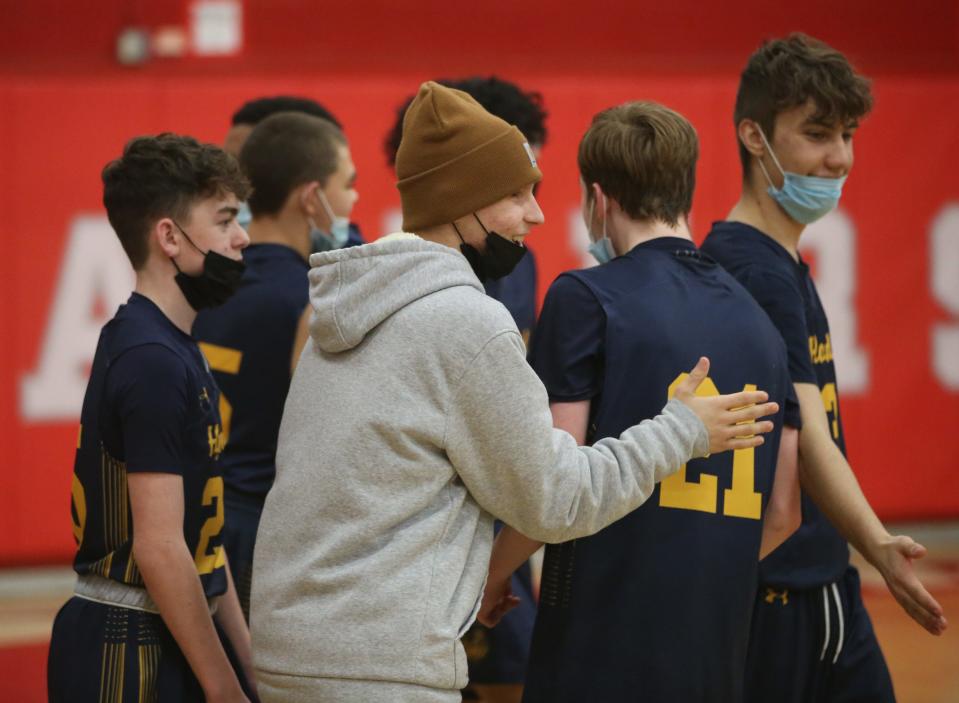 Zach Osterhoudt, a Highland sophomore battling cancer, cheers his junior varsity boys basketball teammates after their victory over Red Hook on Friday.