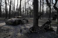 Burned vehicles after a wildfire in Varibobi area, northern Athens, Greece, Wednesday, Aug. 4, 2021. Firefighting planes were resuming operation at first light Wednesday to tackle a major forest fire on the northern outskirts of Athens which raced into residential areas the previous day, forcing thousands to flee their homes amid Greece's worst heatwave in decades. (AP Photo/Thanassis Stavrakis)