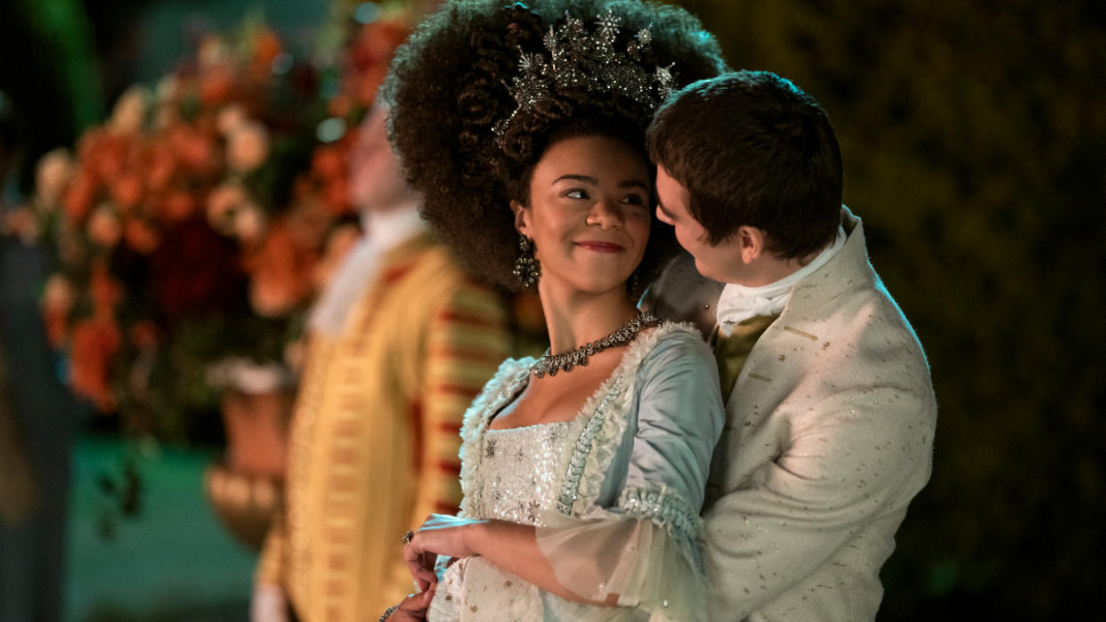  India Amarteifio and Corey Mylchreest in a nighttime embrace outdoors in Queen Charlotte: A Bridgeton Story. 