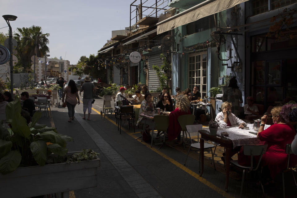 People sit in a restaurant in the Jaffa neighborhood of Tel Aviv, Israel, Wednesday, April 21, 2021. Historic Jaffa's rapid gentrification in recent years is coming at the expense of its mostly Arab lower class. With housing prices out of reach, discontent over the city’s rapid transformation into a bastion for Israel’s ultra-wealthy is reaching a boiling point. (AP Photo/Sebastian Scheiner)