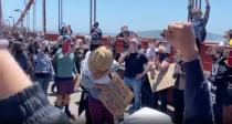 Demonstrators cheer as a man proposes to a woman on the Golden Gate Bridge, San Francisco, California