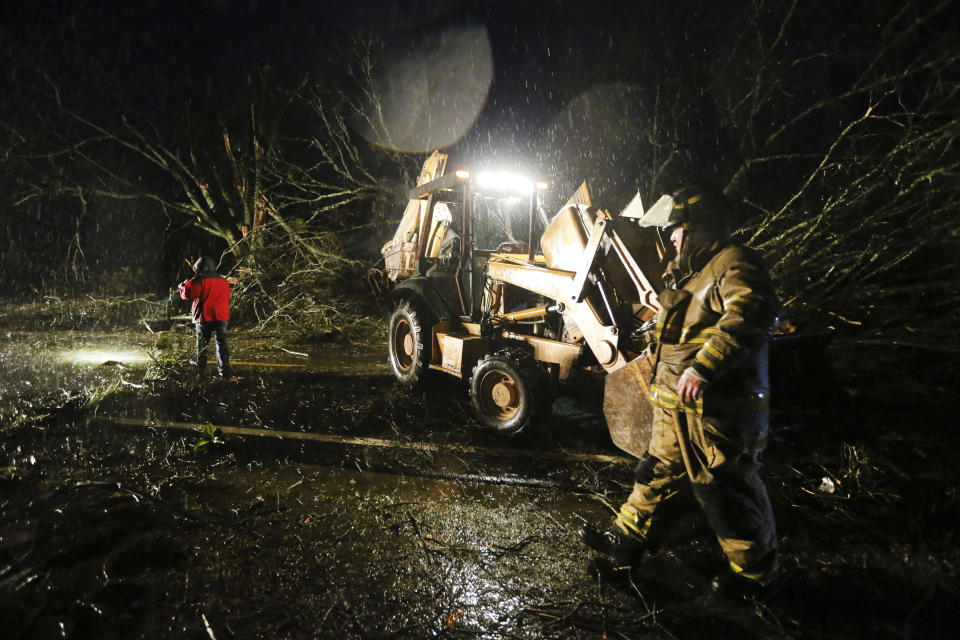 Members of the Pratts-Friendship Fire Department work to check an area on Highway 370 near Baldwyn, Miss., Monday, Dec. 16, 2019, as they clear debris from the road after a tornado passed through the area. (Adam Robison/The Northeast Mississippi Daily Journal via AP)