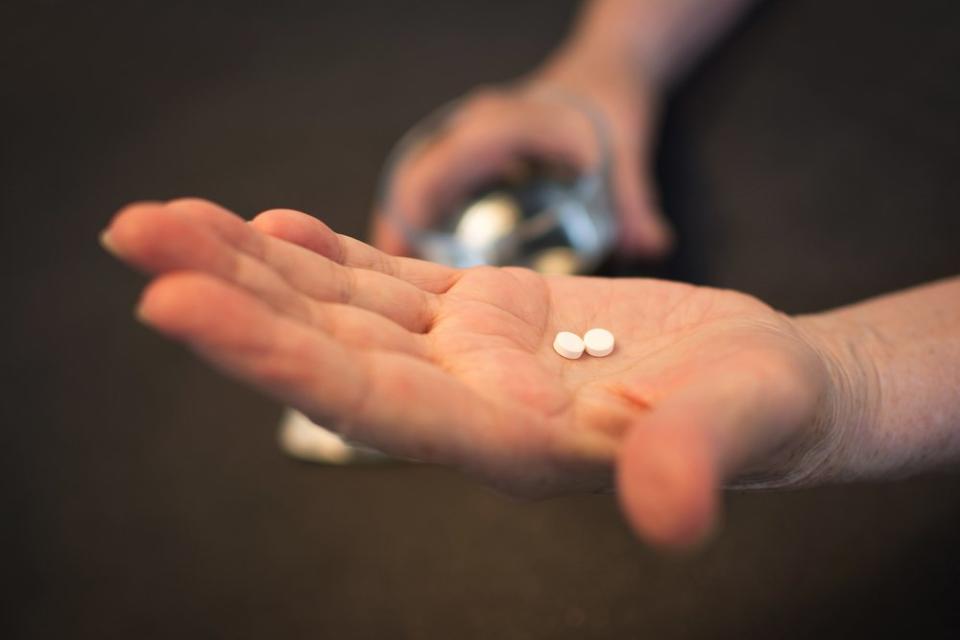 woman holding pills in hand