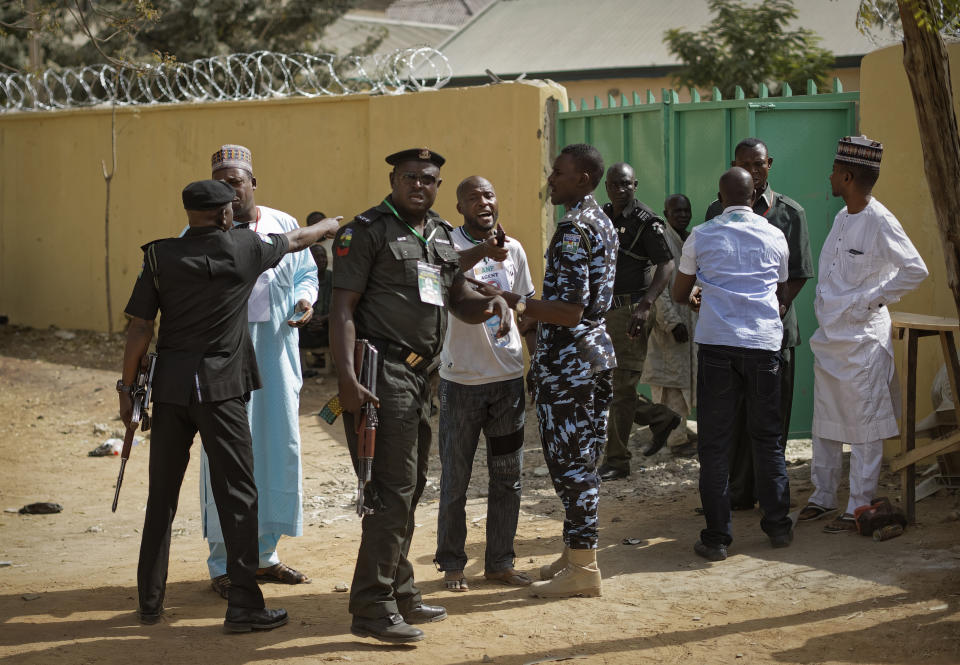 Police attempt to calm opposition supporters who entered a vote compilation center to allege irregularities, before being ejected, in Kano, in northern Nigeria Sunday, Feb. 24, 2019. Vote counting continued Sunday as Nigerians awaited the outcome of a presidential poll seen as a tight race between the president and a former vice president. (AP Photo/Ben Curtis)