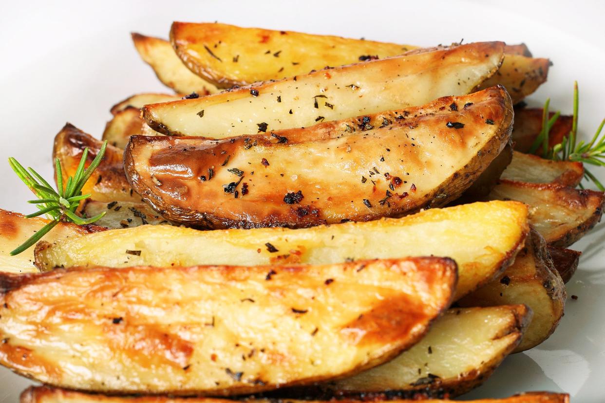 Oven-fresh seasoned potato wedges on a white plate