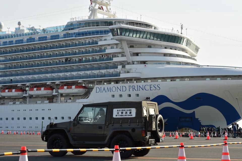 A Japanese Self-Defense Forces Health Corps vehicle enters a cordoned-off area at the Daikoku Pier Cruise Terminal where the quarantined Diamond Princess cruise ship (rear) is anchored, in Yokohama on February 7, 2020, as over 3,700 people remain quarantined onboard due to fears of the new coronavirus. - At least 61 people on board a cruise ship off Japan have tested positive for the new coronavirus, the government said February 7, as thousands of passengers and crew face a two-week quarantine. (Photo by Kazuhiro NOGI / AFP) (Photo by KAZUHIRO NOGI/AFP via Getty Images)