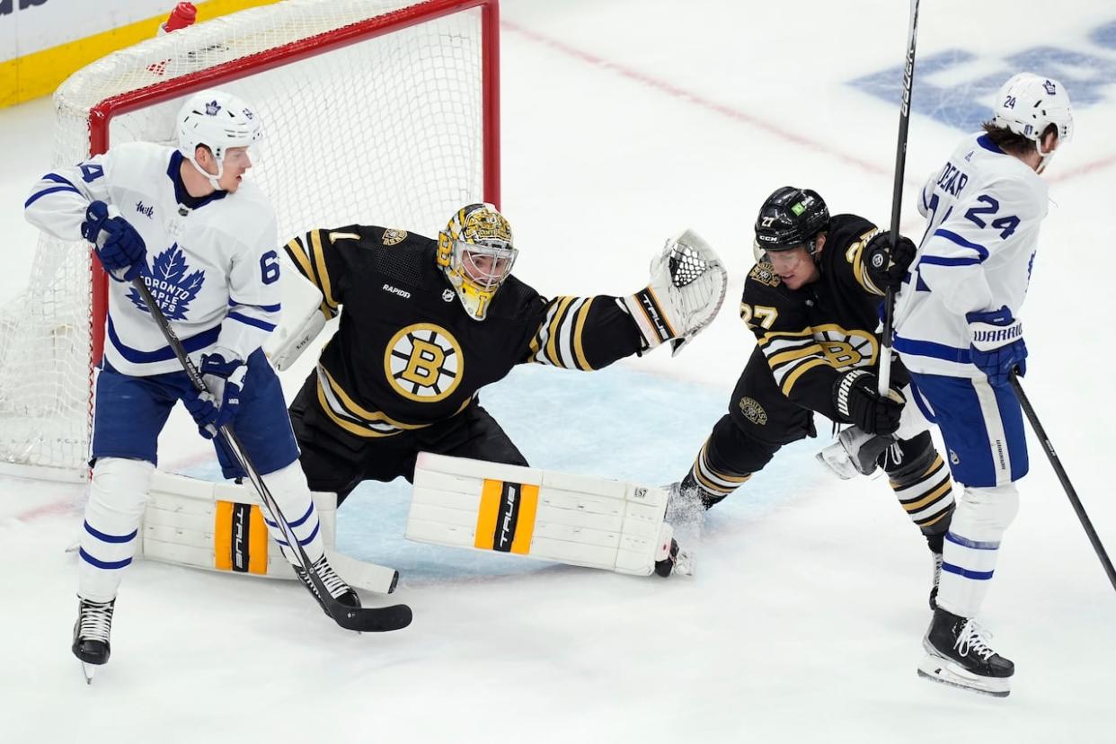 Boston Bruins' Jeremy Swayman (1) makes a glove save behind Toronto Maple Leafs' David Kampf (64) as Hampus Lindholm (27) defends against Toronto Maple Leafs' Connor Dewar (24) during the first period of Game 7 of an NHL hockey Stanley Cup first-round playoff series, Saturday, May 4, 2024, in Boston.  (Michael Dwyer/The Associated Press - image credit)