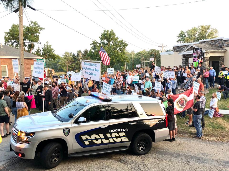 Protesters gather outside a library board meeting Monday, June 26, 2023, in downtown Rockton.