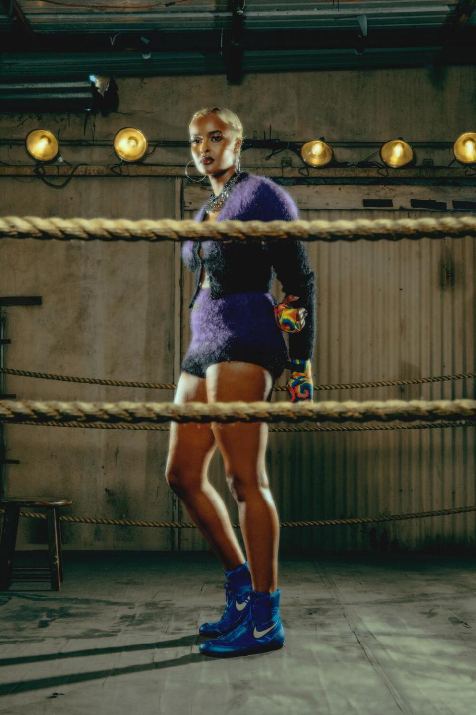 Model poses with hands behind her back in the ring.