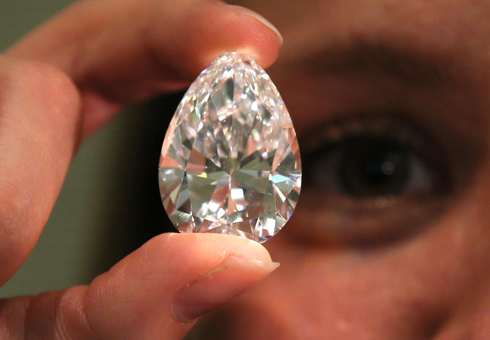 FILE - In this April 29, 2014 file picture a Christie's employee holds a pear shaped D colour flawless 75.97 carat diamond at the auction house in London. The stone will be sold at auction in Geneva on Wednesday evening May 14, 2014 with an estimated value of US$ 13.5-15.5 million. (AP Photo/Alastair Grant,file)