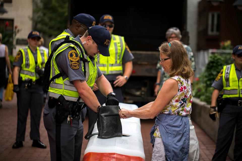 <p>Virginia State Patrol officers check bags at a checkpoint to enter a mall in Charlottesville, Va., on Aug. 11, 2018, in anticipation of the year anniversary of the Unite The Right rally. (Photo: Logan Cyrus/AFP/Getty Images) </p>