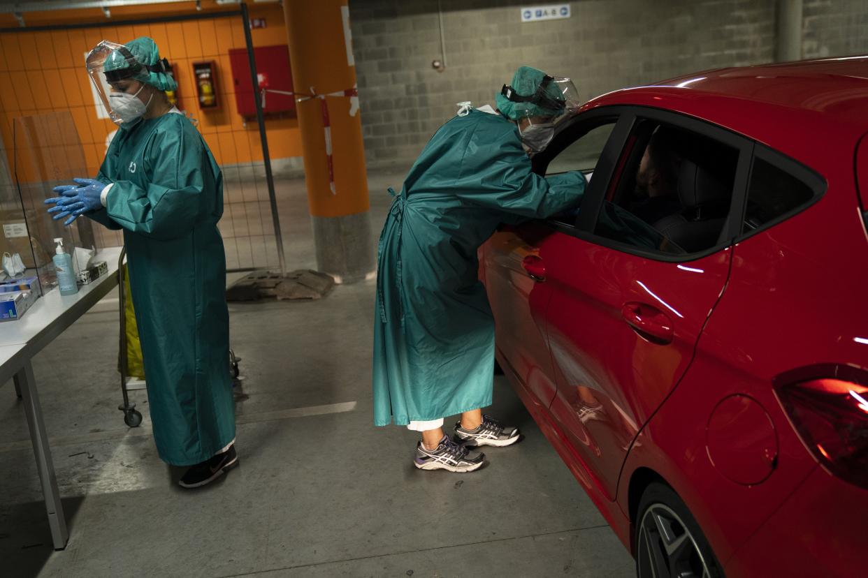 Members of medical personnel take nose swab samples from patients to be tested for coronavirus in a drive-in test station at the MontLegia CHC Hospital in Liege, Belgium on Monday, Aug. 31, 2020.