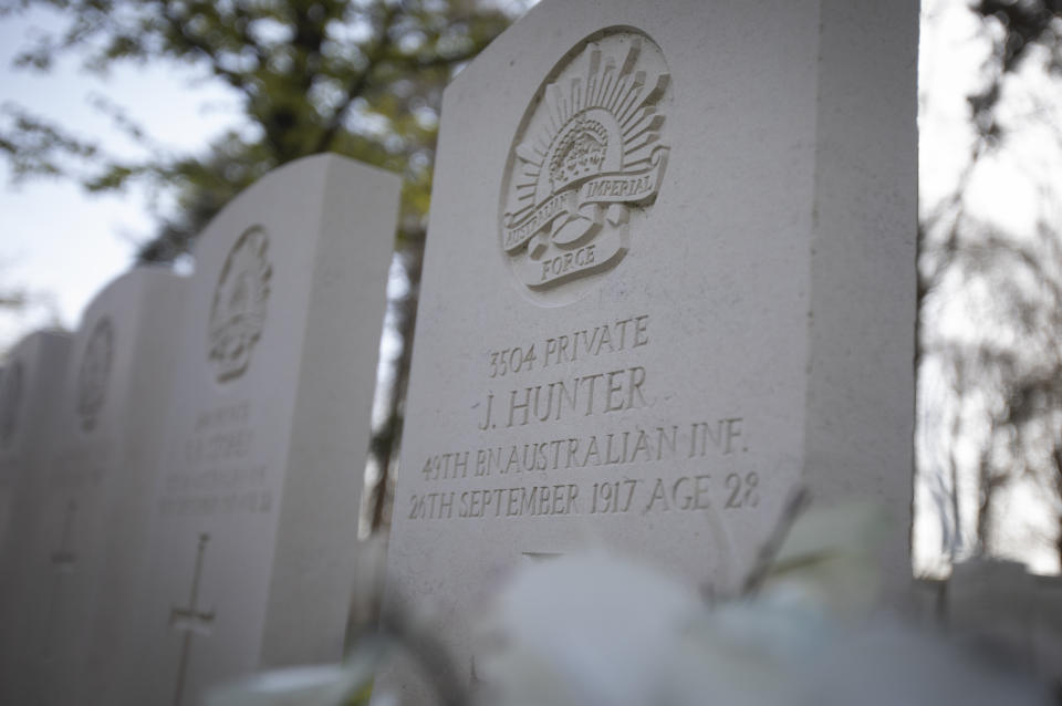 Flowers are placed in front of the grave of Australian World War I soldier John "Jack" Hunter in Buttes New British Cemetery, in Zonnebeke, Belgium, Thursday, April 22, 2021. On another Anzac Day turned lonesome by the global pandemic, solitary actions show all the more how the sacrifices of Australia and New Zealand during World War I are far from forgotten. While global attention will turn at dawn on Sunday to the beaches of Turkey’s Gallipoli where the two emerging countries crafted a sense of nationhood from the horrors of war in April 1915, all along the front line in Europe, small ceremonies will show gratitude over a century after the war ended. (AP Photo/Virginia Mayo)