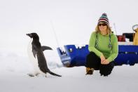 Barbara Tucker, a passenger aboard the trapped ship MV Akademik Shokalskiy looks at an Adelie penguin walking by on the ice off East Antarctica December 29, 2013, some 100 nautical miles (185 km) east of French Antarctic station Dumont D'Urville and about 1,500 nautical miles (2,800 km) south of Hobart, Tasmania. The Snow Dragon Chinese icebreaker was one of three icebreakers sent to free the MV Akademik Shokalskiy, which became stranded on Tuesday in ice driven by strong winds. Ice appeared to be cracking up on Sunday, raising hopes for a rescue as the Aurora Australis, a powerful Australian icebreaker, approached the stranded vessel. The trapped Russian ship, with 74 people on board, left New Zealand on November 28 on a privately funded expedition to commemorate the 100th anniversary of an Antarctic journey led by famed Australian explorer Douglas Mawson. REUTERS/Andrew Peacock (ANTARCTICA - Tags: ENVIRONMENT DISASTER) FOR EDITORIAL USE ONLY. NOT FOR SALE FOR MARKETING OR ADVERTISING CAMPAIGNS