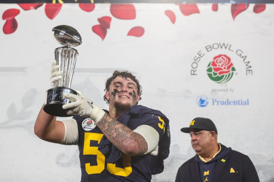 Michigan defensive lineman Mason Graham (55) lifts the Rose Bowl trophy to celebrate a 27-20 Rose Bowl win over Alabama at the 2024 Rose Bowl in Pasadena, Calif., on Monday, Jan. 1, 2024.