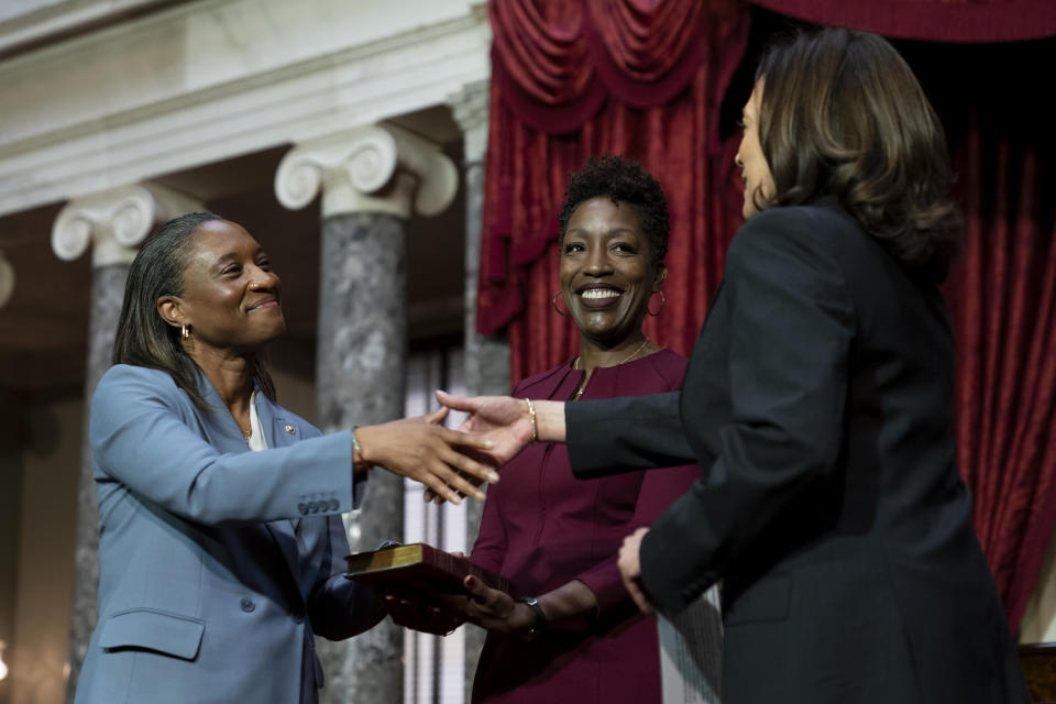 Vice President Kamala Harris, right, swears in Laphonza Butler, D-Calif., left, to the Senate to succeed the late Sen. Dianne Feinstein during a re-enactment of the swearing-in ceremony on Tuesday, Oct. 3, 2023, on Capitol Hill in Washington. Butler's wife, Neneki Lee, center, holds the Bible. (AP Photo/Stephanie Scarbrough)