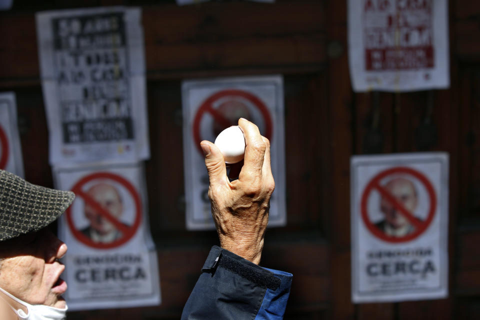 David Roura, a member of the 1968-71 student movement, prepares to throw an egg at the front gate residence of former Mexican President Luis Echeverría, (1970-1976), during a march to commemorate the 50th anniversary of the student massacre of 1971 known as "El Halconazo," in Mexico City, Thursday, June 10, 2021. The attack, also known as the Corpus Christi massacre, was carried out by a group of men apparently recruited by the government to dissolve a pro-democracy student demonstration. (AP Photo/Marco Ugarte)