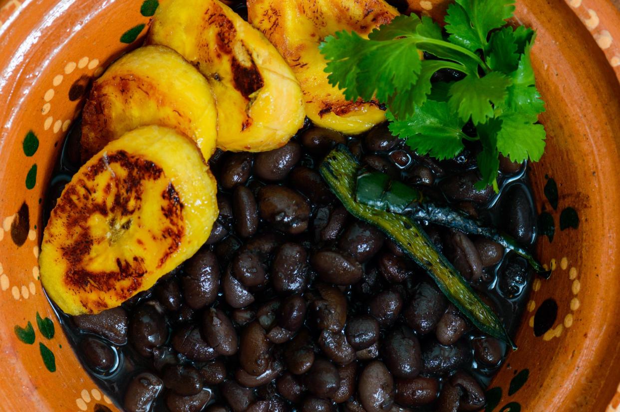 Traditional Mexican and Central American breakfast. Black beans and plantain with boiled egg and cilantro. Coffee on the side.