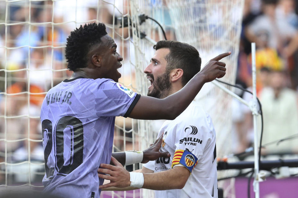 ARCHIVO - Vinicius Junior del Real Madrid apunta hacia hinchas del Valencia frente al zaguero Juan Gayá durante el partido de la Liga de España, el 21 de mayo de 2023, en el estadio Mestalla de Valencia. (AP Foto/Alberto Saiz)