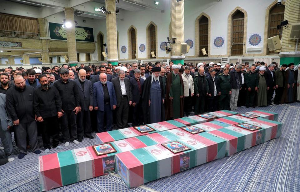 Supreme Leader Ayatollah Ali Khamenei, center with black turban, leads a prayer over the flag-draped coffins of the Revolutionary Guards members who were killed in an airstrike widely blamed on Israel in Syria on Monday (AP)