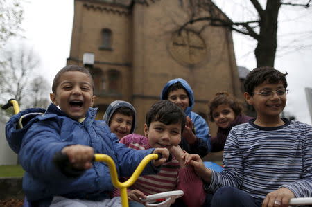 Local resident Sebastian Possner launched a neighborhood initiative nearly a month ago to protest against the conversion of the church. Now he says his kids are playing with the refugee children, like those from Syria in this picture, and that he's donated bicycles and toys. REUTERS/Ina Fassbender