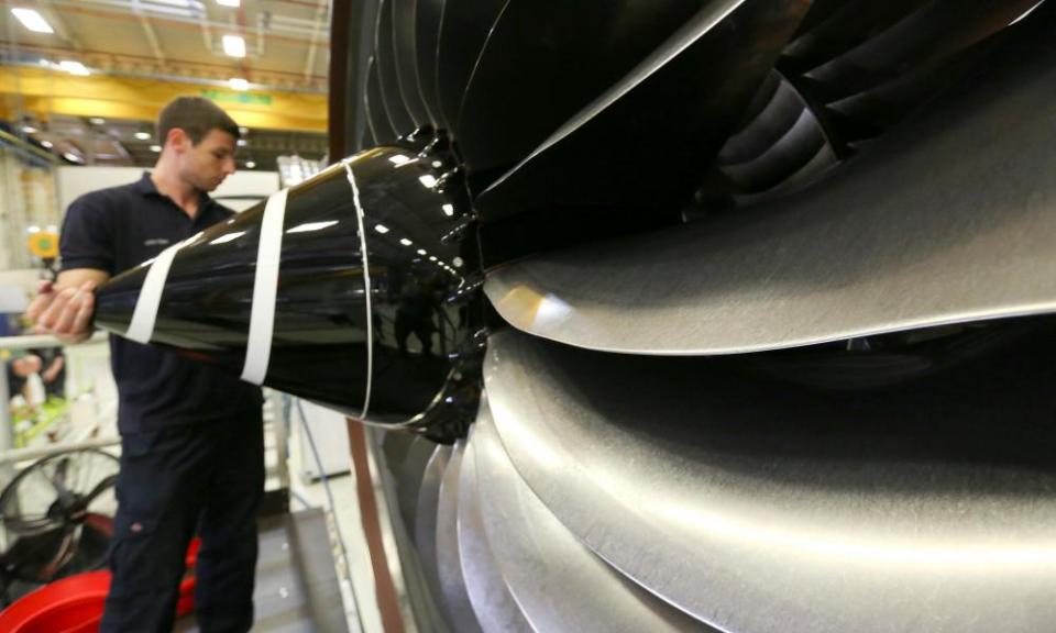 An employee checks the nose cone of a Trent XWB aircraft engine at the Rolls-Royce factory in Derby. 