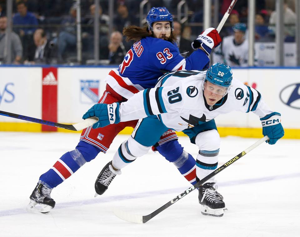 New York Rangers center Mika Zibanejad (93) and San Jose Sharks forward Fabian Zetterlund (20) battle for position during the first period of an NHL hockey game Sunday, Dec. 3, 2023, in New York.