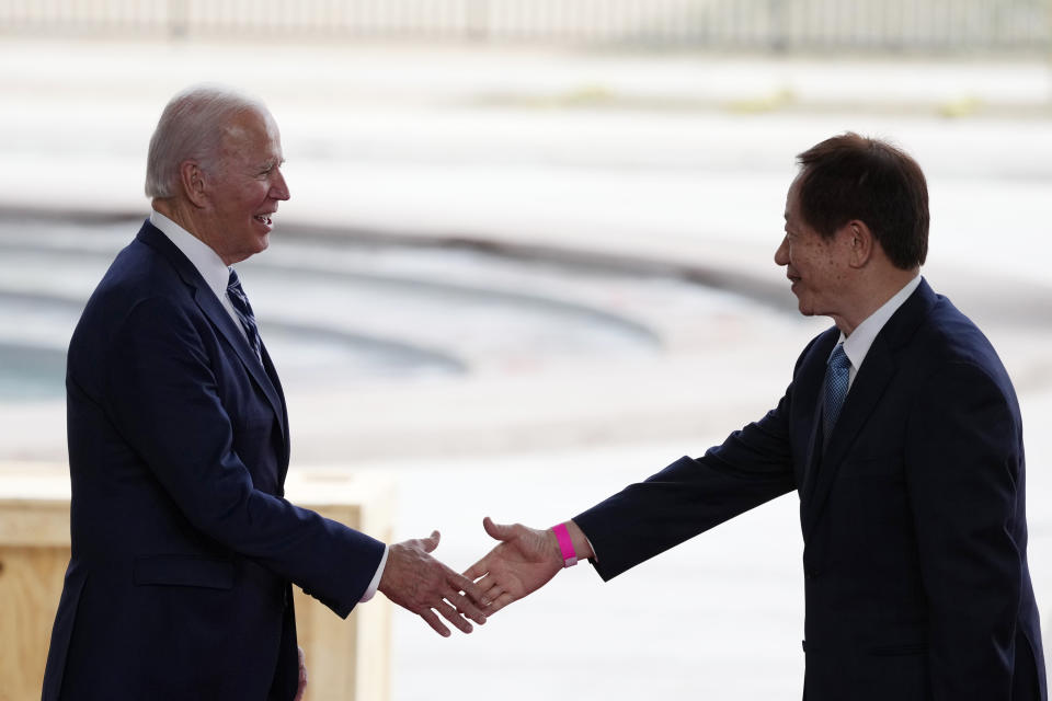 President Joe Biden (left) shakes hands with Taiwan Semiconductor Manufacturing Company Chairman Mark Liu (right) as they meet on stage after touring the TSMC facility under construction in Phoenix, Tuesday, December 6, 2022.  (AP Photo/Ross D. Franklin)