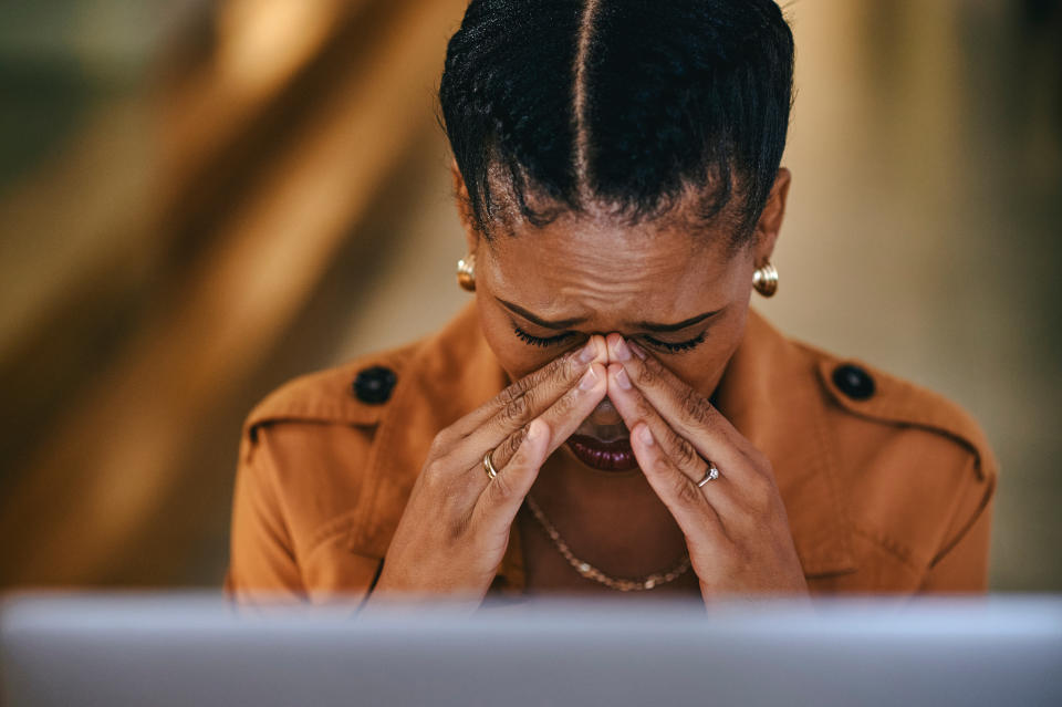 person with their hands at the nose in grief