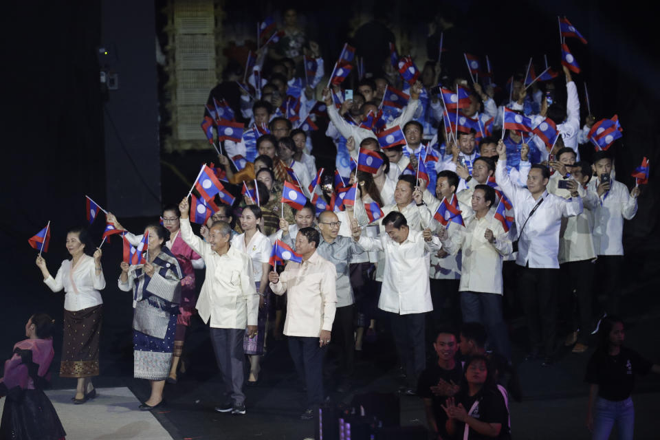 Laos' team wave flags during the opening ceremony of the 30th South East Asian Games at the Philippine Arena, Bulacan province, northern Philippines on Saturday, Nov. 30, 2019. (AP Photo/Aaron Favila)