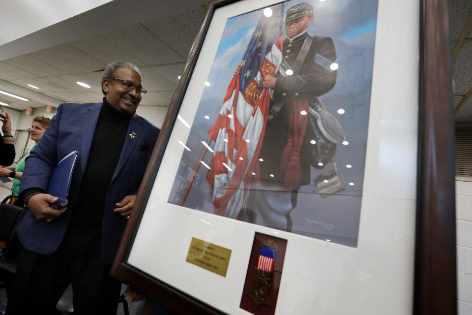 Carl Cruz, a descendant of Sgt. William Carney walks past a painting of his relative who is Carney Academy's namesake. Sgt. William H. Carney was the first Black recipient of the Medal of Honor.