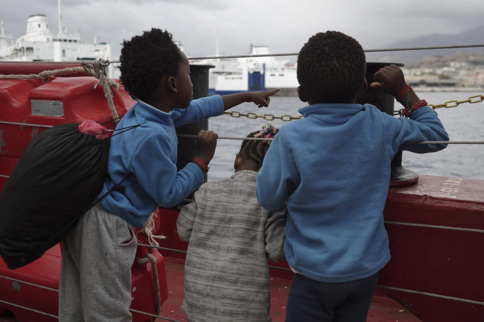 Children wave at a boat from aboard the Ocean Viking as it reaches the port of Messina, Italy, Tuesday, Sept. 24, 2019. The humanitarian ship has docked in Italy to disembark 182 men, women and children rescued in the Mediterranean Sea after fleeing Libya. (AP Photo/Renata Brito)