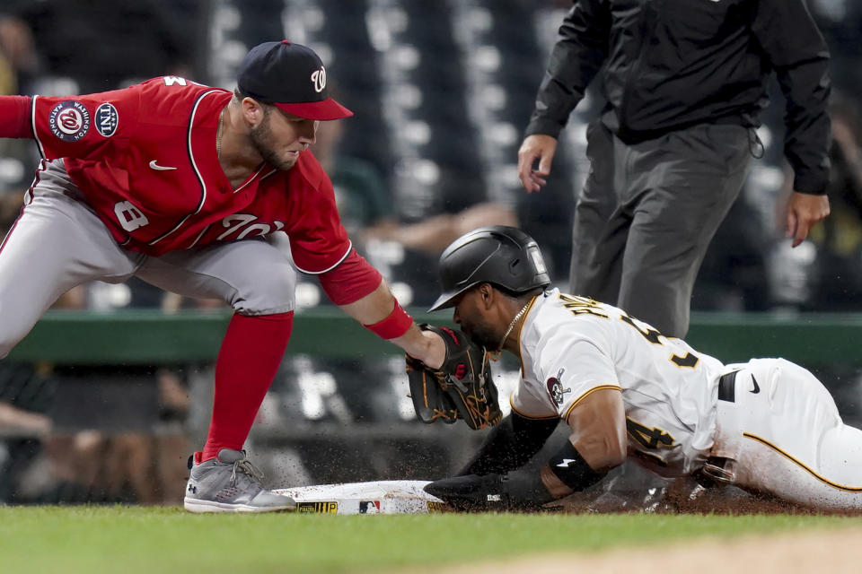 Pittsburgh Pirates' Miguel Andujar advances to third base next to Washington Nationals third baseman Carter Kieboom on a ball hit by Ji Hwan Bae during the fifth inning of a baseball game in Pittsburgh, Tuesday, Sept. 12, 2023. (AP Photo/Matt Freed)