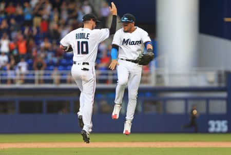 Mar 31, 2019; Miami, FL, USA; Miami Marlins shortstop JT Riddle (10) and second baseman Miguel Rojas celebrate after defeating the Colorado Rockies at Marlins Park. Mandatory Credit: Sam Navarro-USA TODAY Sports