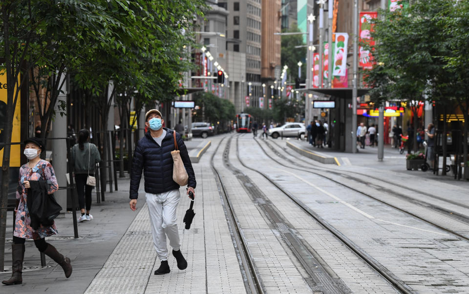 Two people wearing face masks on George Street in the Sydney CBD.