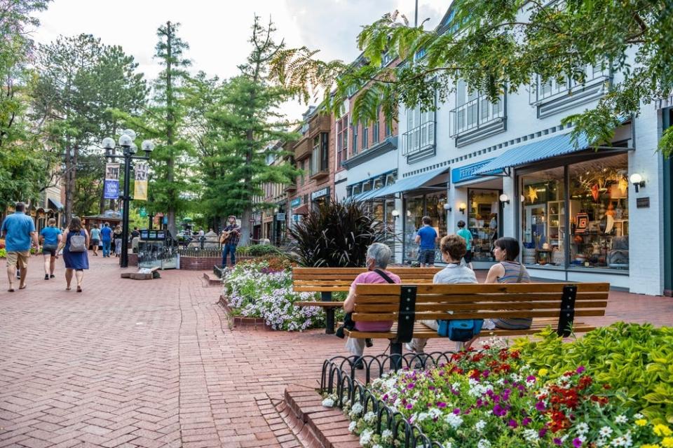 People sitting on a bench on a street in Boulder, Colorado.