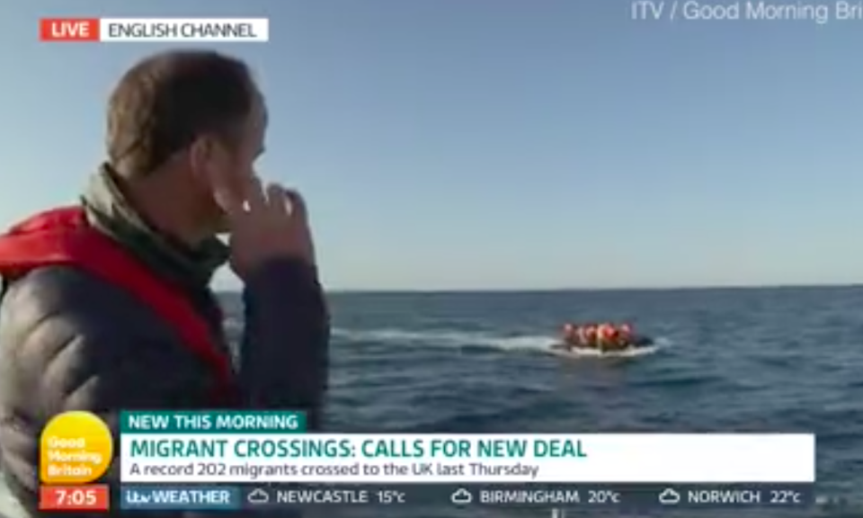 Good Morning Britain reporter Jonathan Swain looks out at the boat filled with migrants (ITV/GMB)