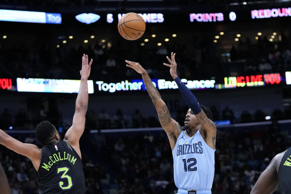 Memphis Grizzlies guard Ja Morant (12) shoots against New Orleans Pelicans guard CJ McCollum (3) in the first half of an NBA basketball game in New Orleans, Tuesday, Dec. 26, 2023. (AP Photo/Gerald Herbert)