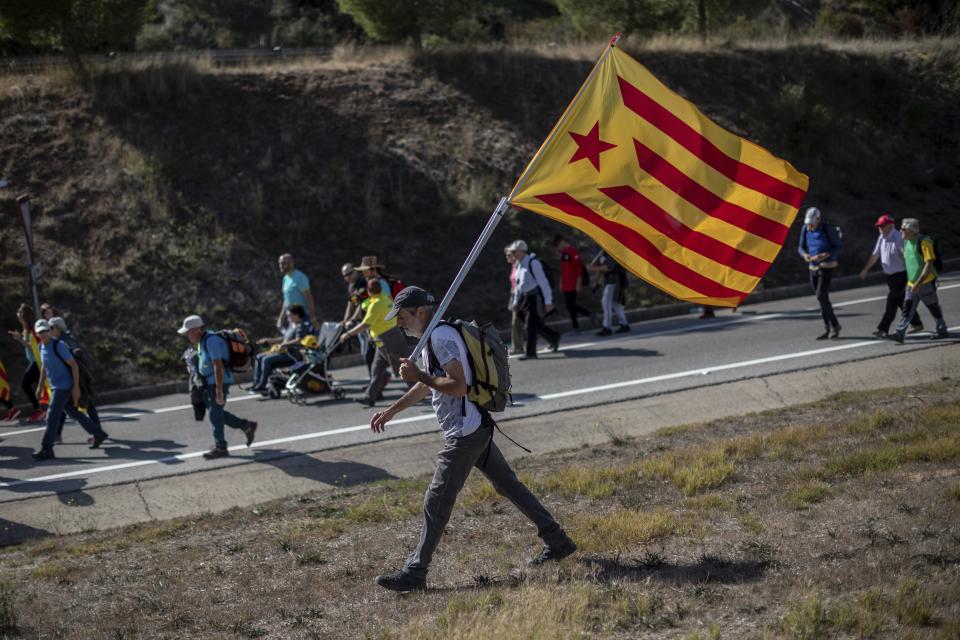 A demonstrator carry a pro-independence Estelada flag during a march near Navas, Spain, Wednesday, Oct. 16, 2019. Thousands of people have joined five large protest marches across Catalonia that are set to converge on Barcelona, as the restive region reels from two straight days of violent clashes between police and protesters. The marches set off from several Catalan towns and aimed to reach the Catalan capital by Friday. (AP Photo/Bernat Armangue)